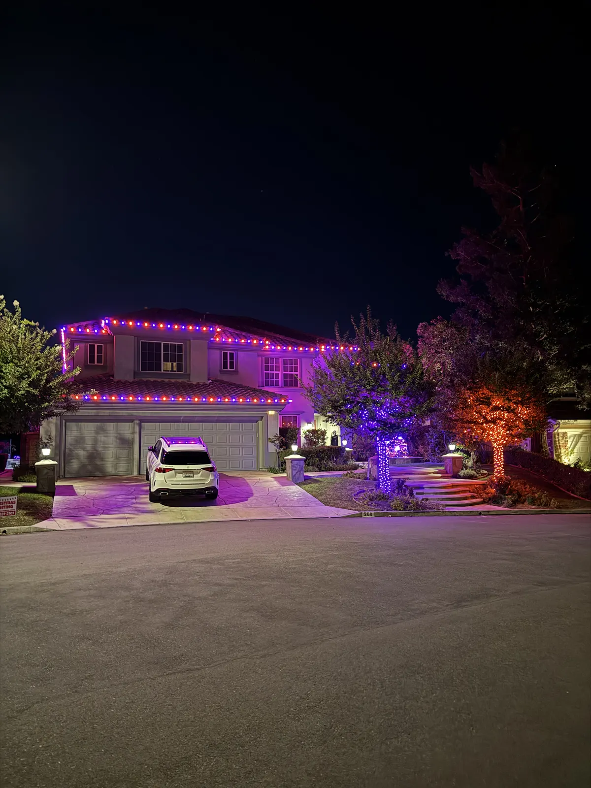 Halloween lighting installation on a home at night