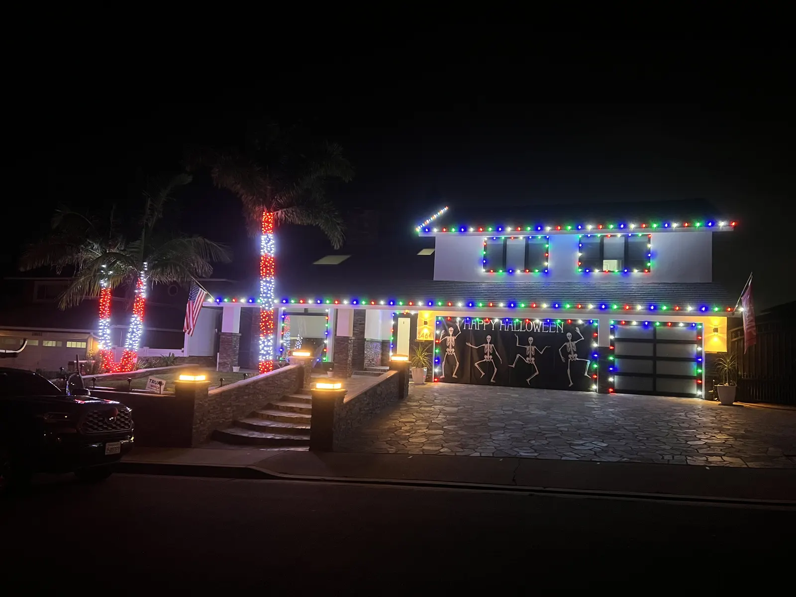 Single-story home with multicolor Christmas lights on the roofline and lit candy cane posts