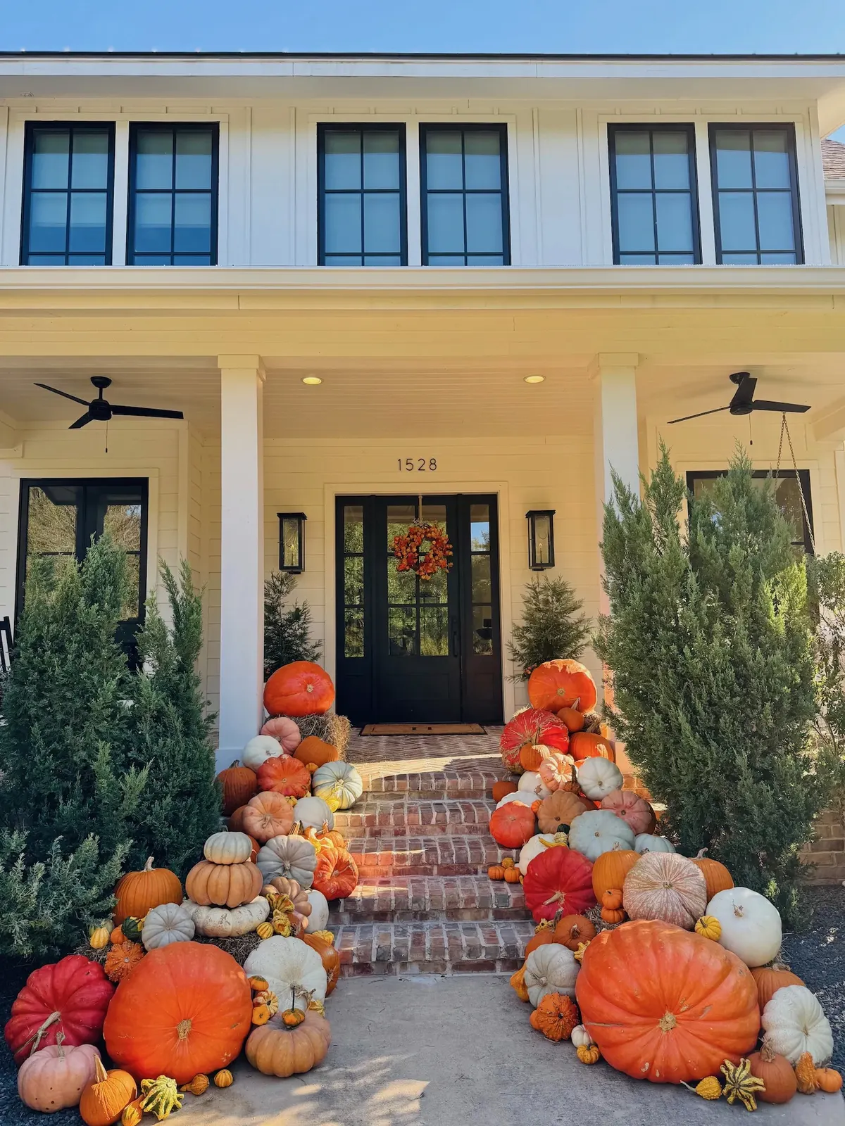 Pumpkin display covering brick steps leading to a white home front door