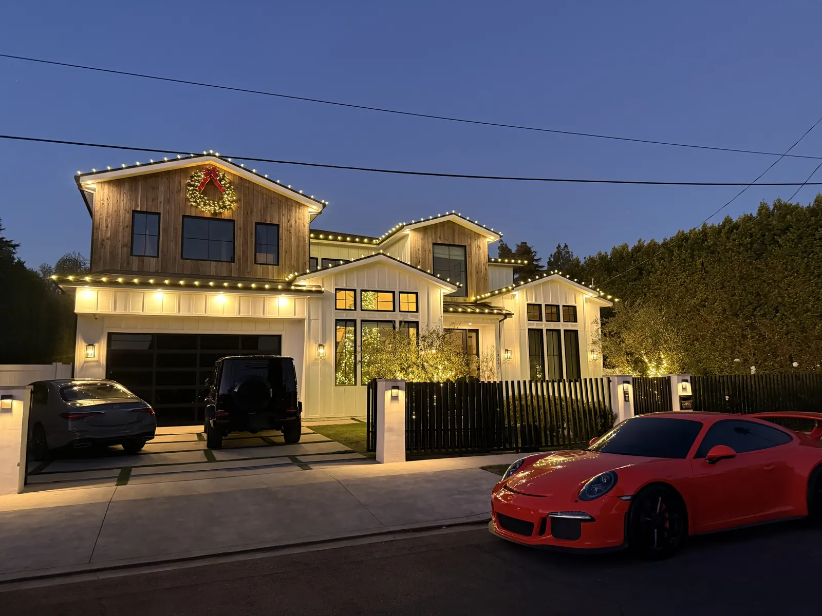Two-story home in Sherman Oaks with warm white lights along the roofline and a lit wreath over the garage