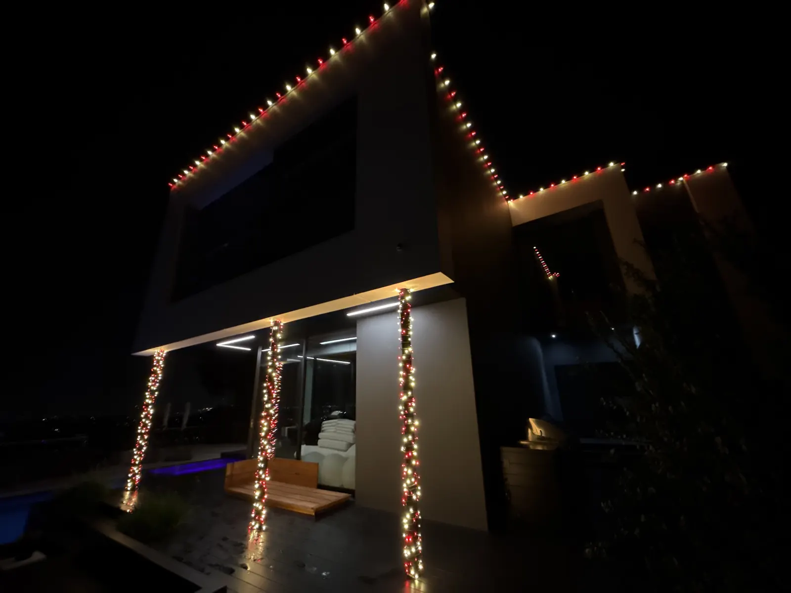 Light-wrapped columns and roofline lights on a modern home in Studio City