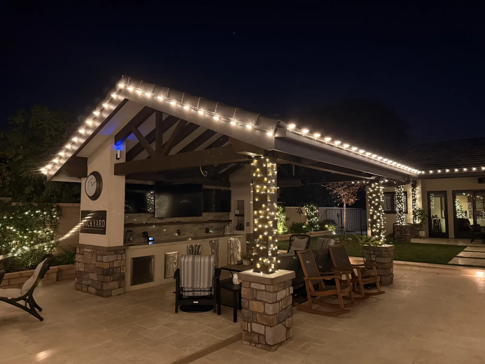 Covered patio in Yorba Linda with warm white lights along the roof edge and light-wrapped columns